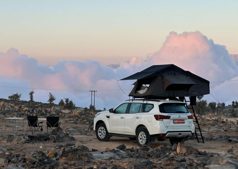 4x4 avec une tente de toit dans les montagnes au dessus des nuages
